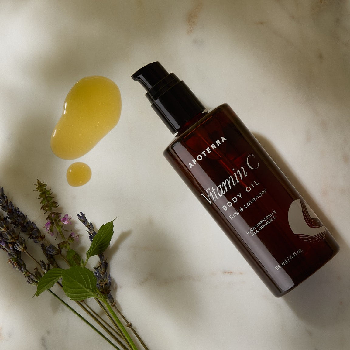 Aoterra Vitamin C body oil bottle with lavender flowers on a marble surface