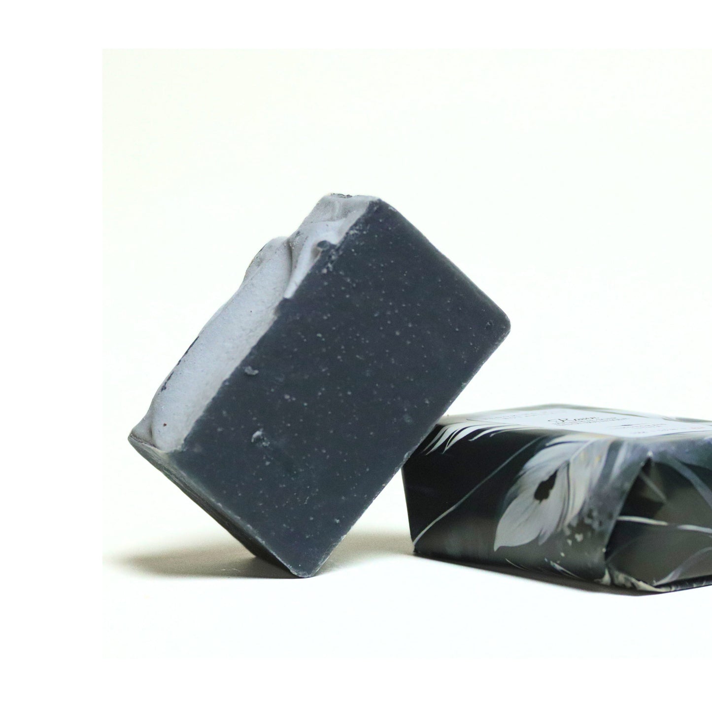 Blooming Wild Raven Soap bar, deep charcoal color with lemongrass scent, made with activated charcoal, shea butter, and natural plant oils for purifying and refreshing skin.