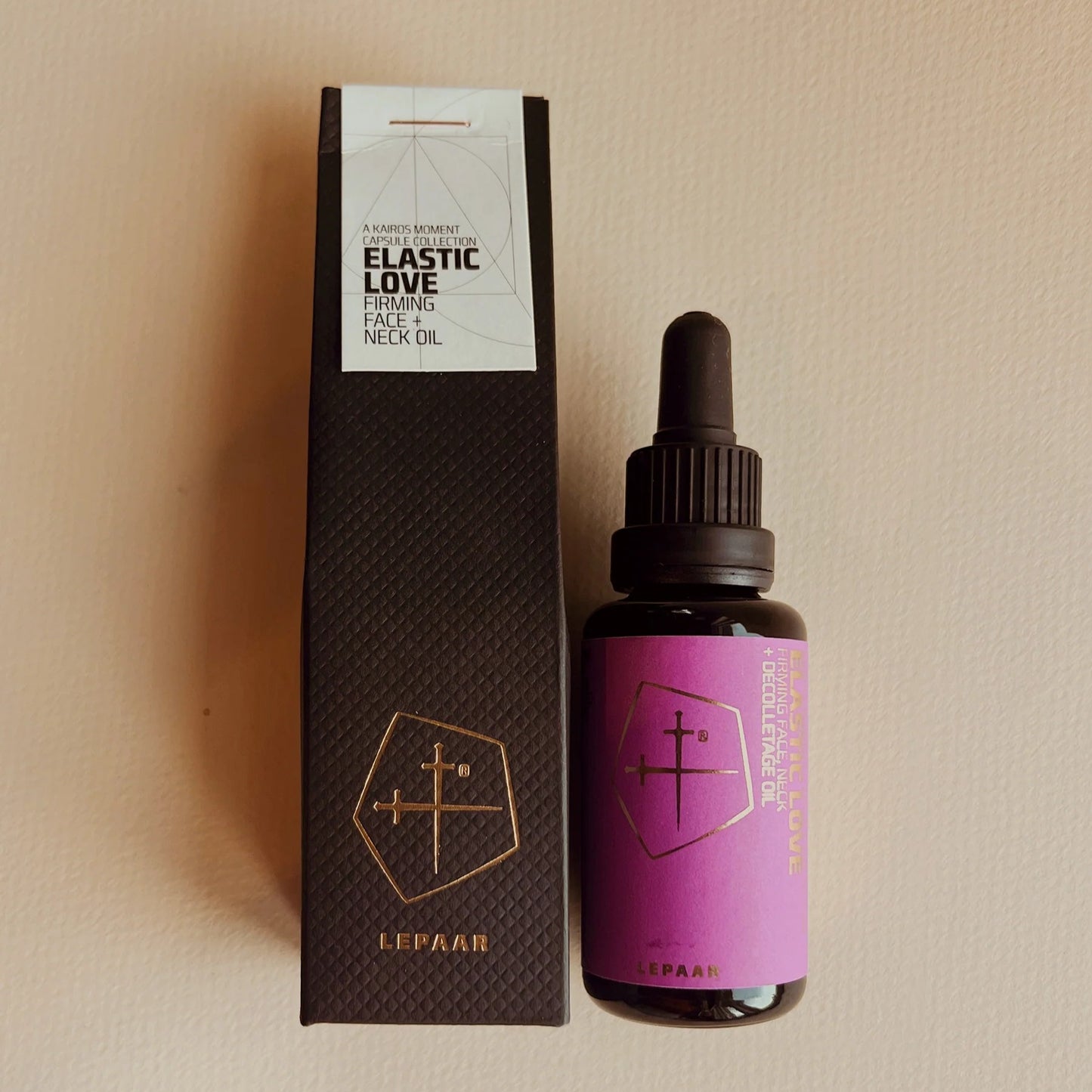 Bottle of 'Elastic Love' face and neck oil with packaging on a beige background. LEPAAR Elastic Love / Firming Face + Neck Oil / Zero Essential Oils ALWAYS SHOW