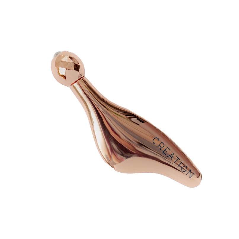 CREATION Rose Gold Facial Contour Massage Tool used for sculpting the face and massaging tension points on the forehead, brow, and jawline.