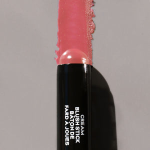 Cream blush stick with pink shade on a gray background
