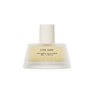 A frosted glass perfume bottle with a matte white cap, containing a pale yellow liquid. The label reads 'CYAN NORI 100% NATURAL EAU DE PARFUM' and features the brand name 'Abel' embossed near the bottom.