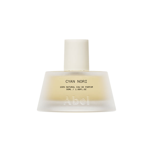 A frosted glass perfume bottle with a matte white cap, containing a pale yellow liquid. The label reads 'CYAN NORI 100% NATURAL EAU DE PARFUM' and features the brand name 'Abel' embossed near the bottom.