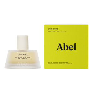 A bottle of Abel Cyan Nori Eau de Parfum next to its bright yellow-green packaging box, set against a plain white background.