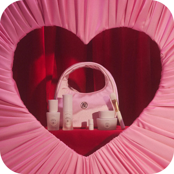 Pink cosmetic bag with skincare products inside, framed by a heart-shaped pink border.