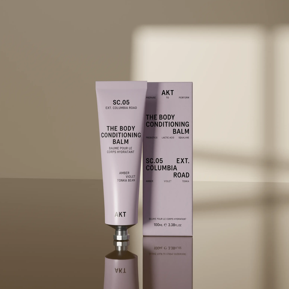 A lavender purple ze tube of AKT London The Body Conditioning Balm, scent SC.05 Columbia Road, on a clean off-white background.