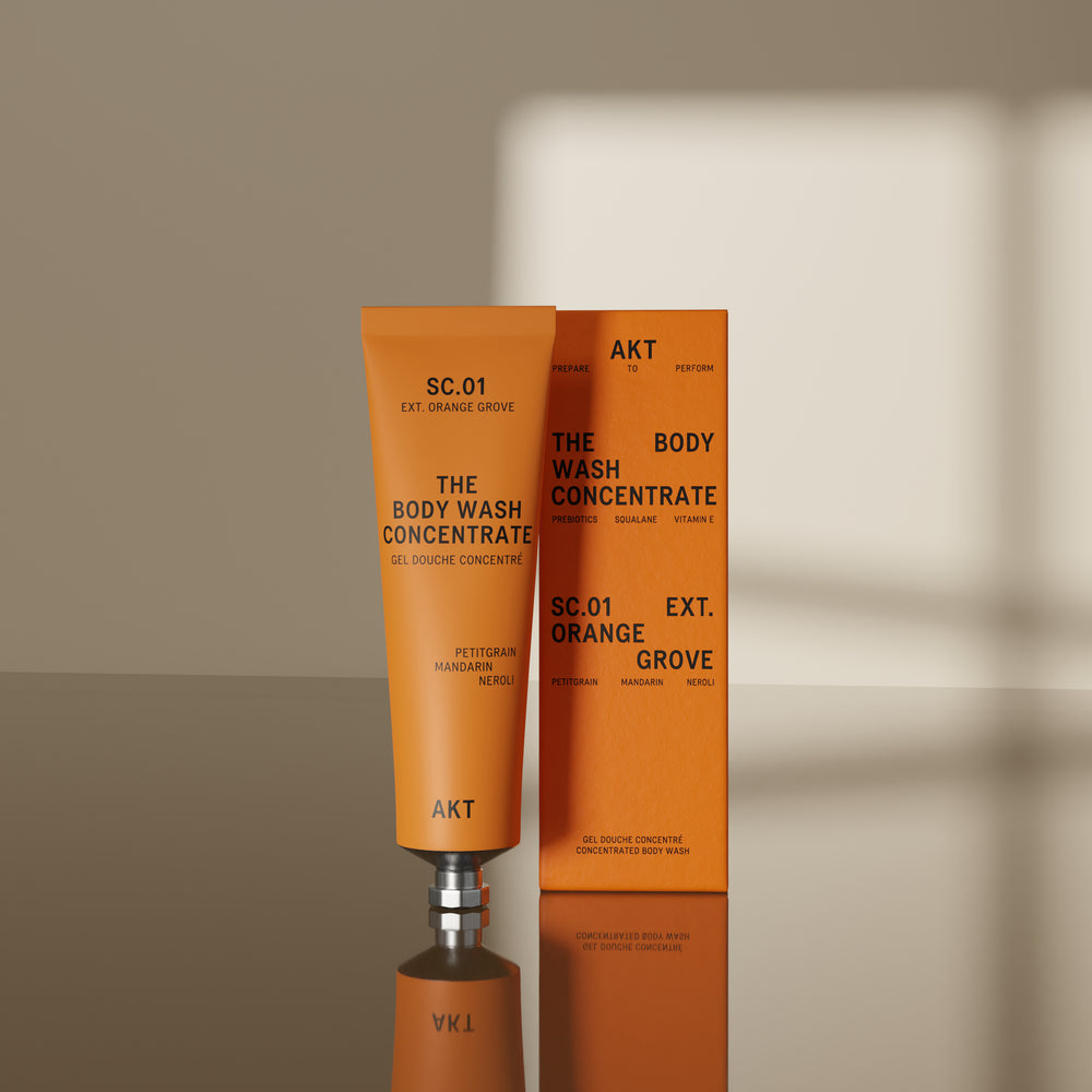 A squeeze tube of AKT London The Body Wash Concentrate in SC.01 Orange Grove on white background.