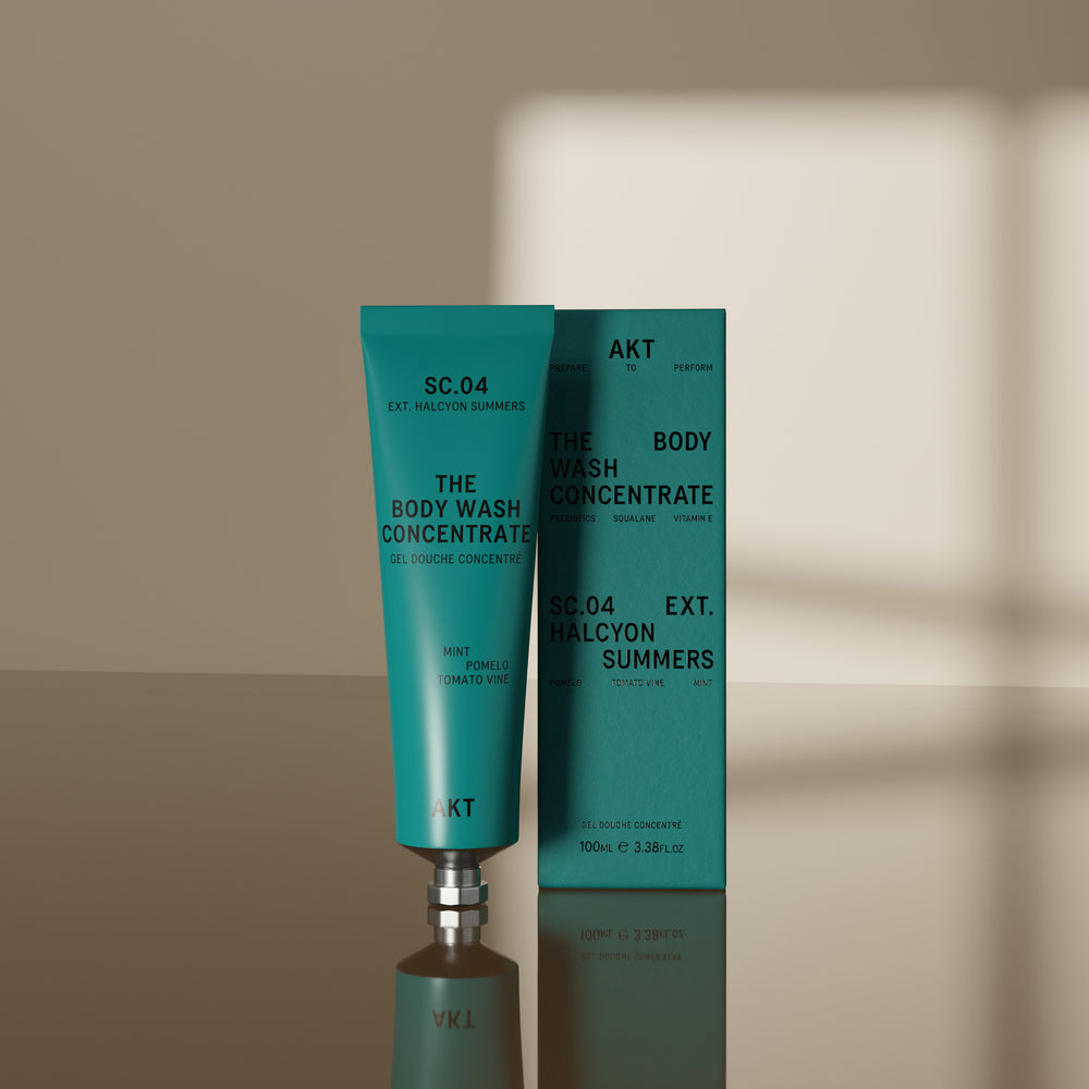 A teal squeeze tube of AKT London body wash concentrate labeled 'SC.04 Halycon Summers, on white background.