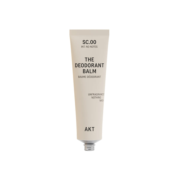 A single tube of deodorant balm by AKT London on a plain white background. The tube is a warm off-white/cream color with black text.