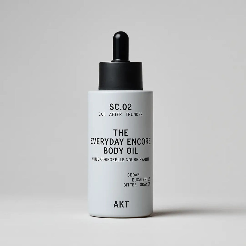 A white bottle with dropper of AKT London The Everyday Encore Body Oil with a scent SC.02 After Thunder, shown on a white background.