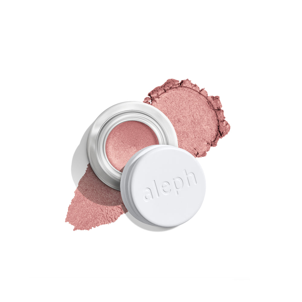 A small open jar of ALEPH blush with a white lid resting beside it, showing a shimmery dusty rose pink cream product with matching powder smears on a clean white background.