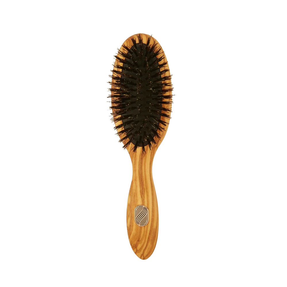 Wooden hairbrush with black bristles on a white background
