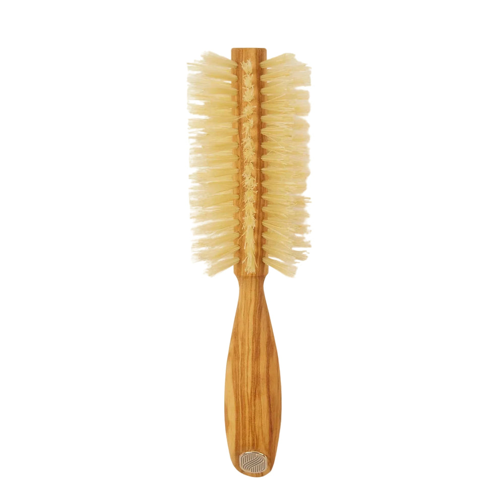 Wooden hairbrush with bristle head on a beige background