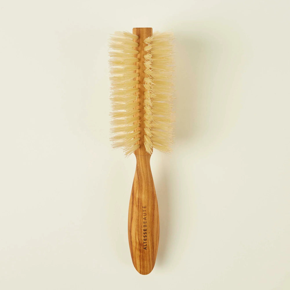 Wooden hairbrush with bristle head on a beige background