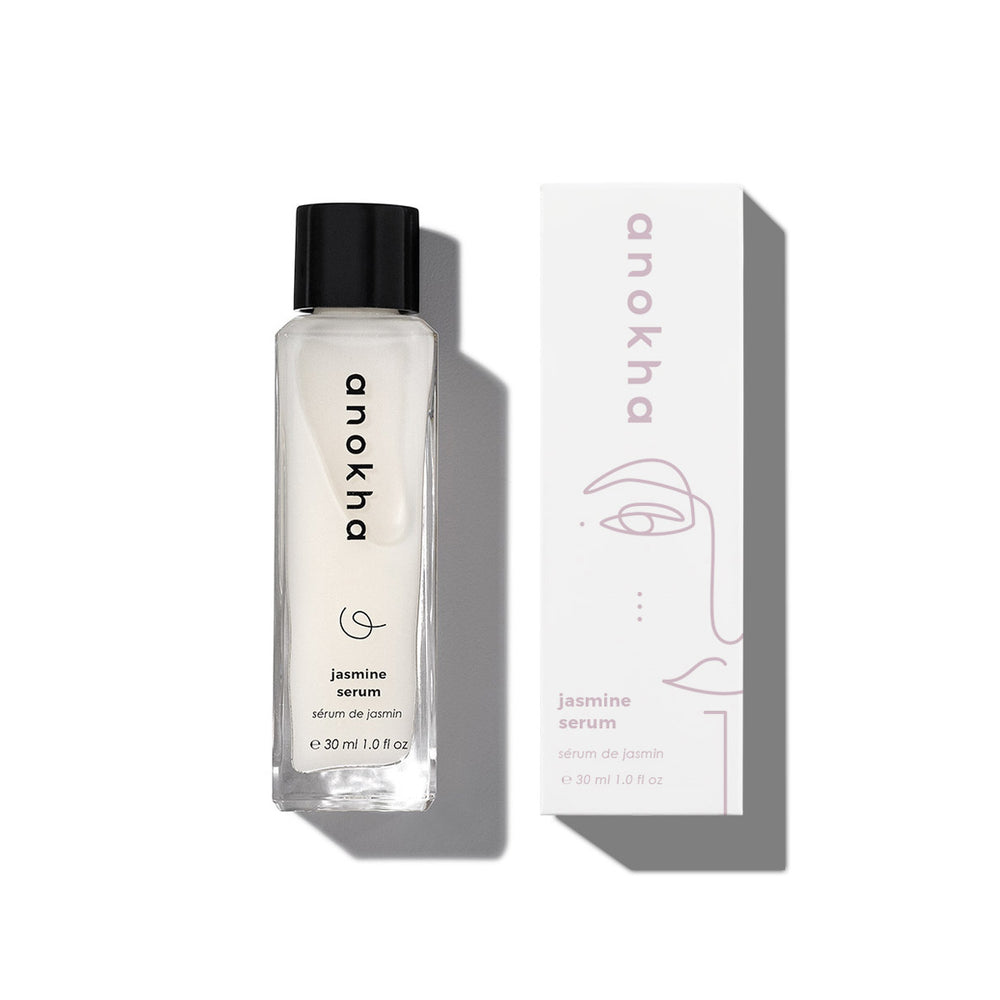 ANOKHA Jasmine Serum bottle with a backdrop of jasmine flowers, showcasing a hydrating facial serum that promotes a glowing and dewy complexion.