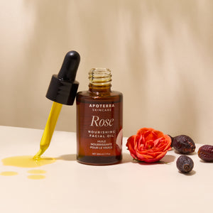 Apoterra Rose Nourishing Facial Oil with dropper and rose petals on a beige background