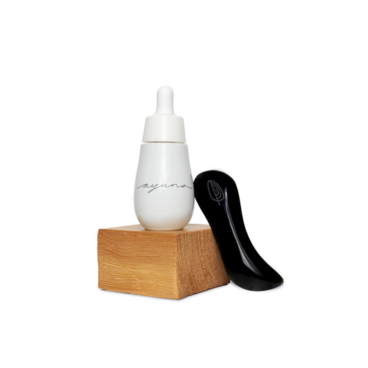 Ayuna Oleum Obsidianum Limited Edition Set with Cellular Oil Skin Revival Serum and handcrafted Ixtli Obsidian tool, designed for a revitalizing facial ceremony.