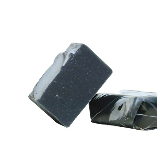 Blooming Wild Raven Soap bar, deep charcoal color with lemongrass scent, made with activated charcoal, shea butter, and natural plant oils for purifying and refreshing skin.