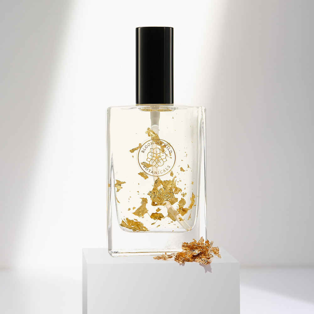 Blooming Wild Winter’s Light Botanical Body Oil with slow-infused dandelion and 24k gold flakes in a glass bottle, designed to soften and refresh skin.
