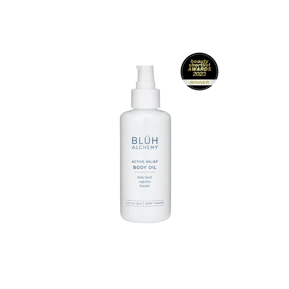 BLUH ALCHEMY Active Relief Body Oil is a luxurious nourishing body oil with Copaiba, Hinoki, Arnica, and Holy Basil for hydrated, smooth skin. In white glass bottle with a pump on white background