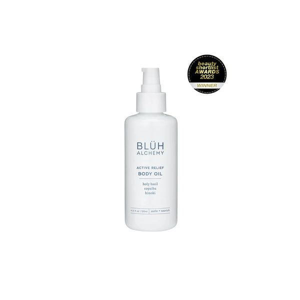 BLUH ALCHEMY Active Relief Body Oil is a luxurious nourishing body oil with Copaiba, Hinoki, Arnica, and Holy Basil for hydrated, smooth skin. In white glass bottle with a pump on white background