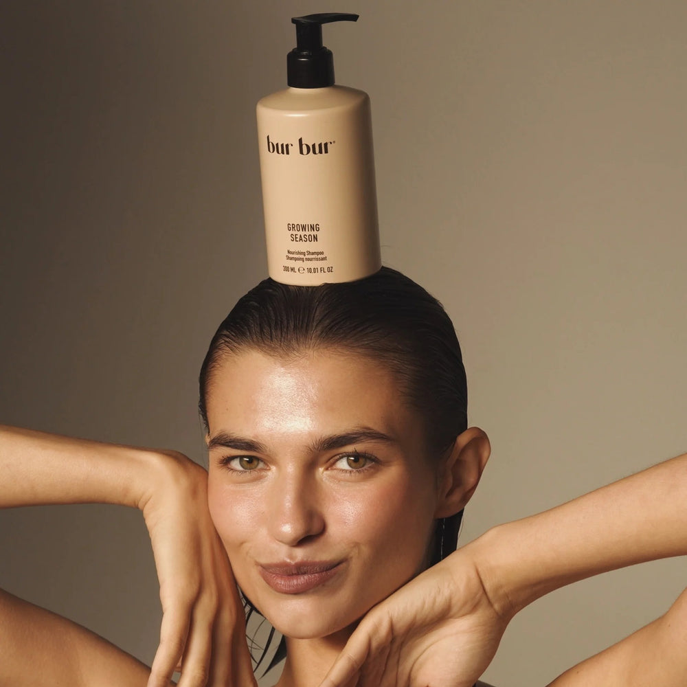 Beige shampoo bottle with black pump labeled BUR BUR Growing Season Nourishing Shampoo on a white background