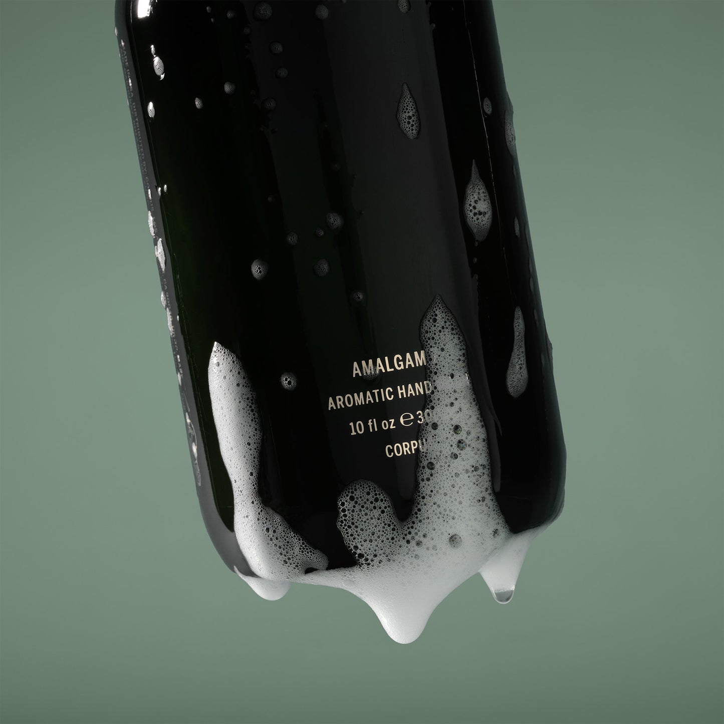 Amalgam Aromatic Hands Liquid soap bottle with foam on a green background. CORPUS Aromatic Hand Wash Amalgam 7