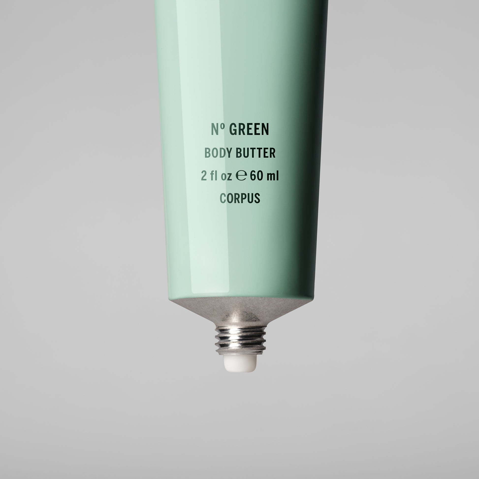 Mint green body butter tube with text on a gray background. CORPUS Body Butter Nº Green Mini