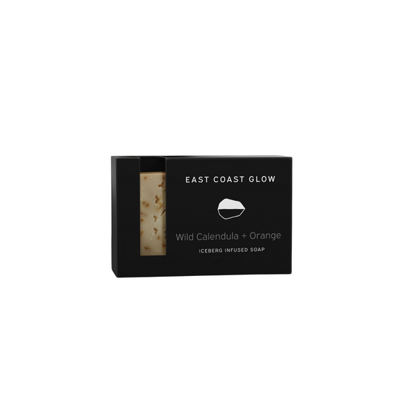Bar of East Coast Glow Wild Calendula + Orange Iceberg Infused Soap with calendula petals and orange zest, showcasing a creamy, natural soap enriched with wildcrafted botanicals and iceberg water.