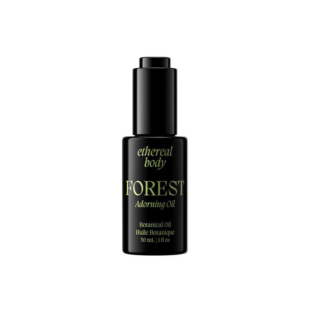 A black bottle of Forest Adorning Oil by Ethereal Body with gold lettering, shown against a solid white background.