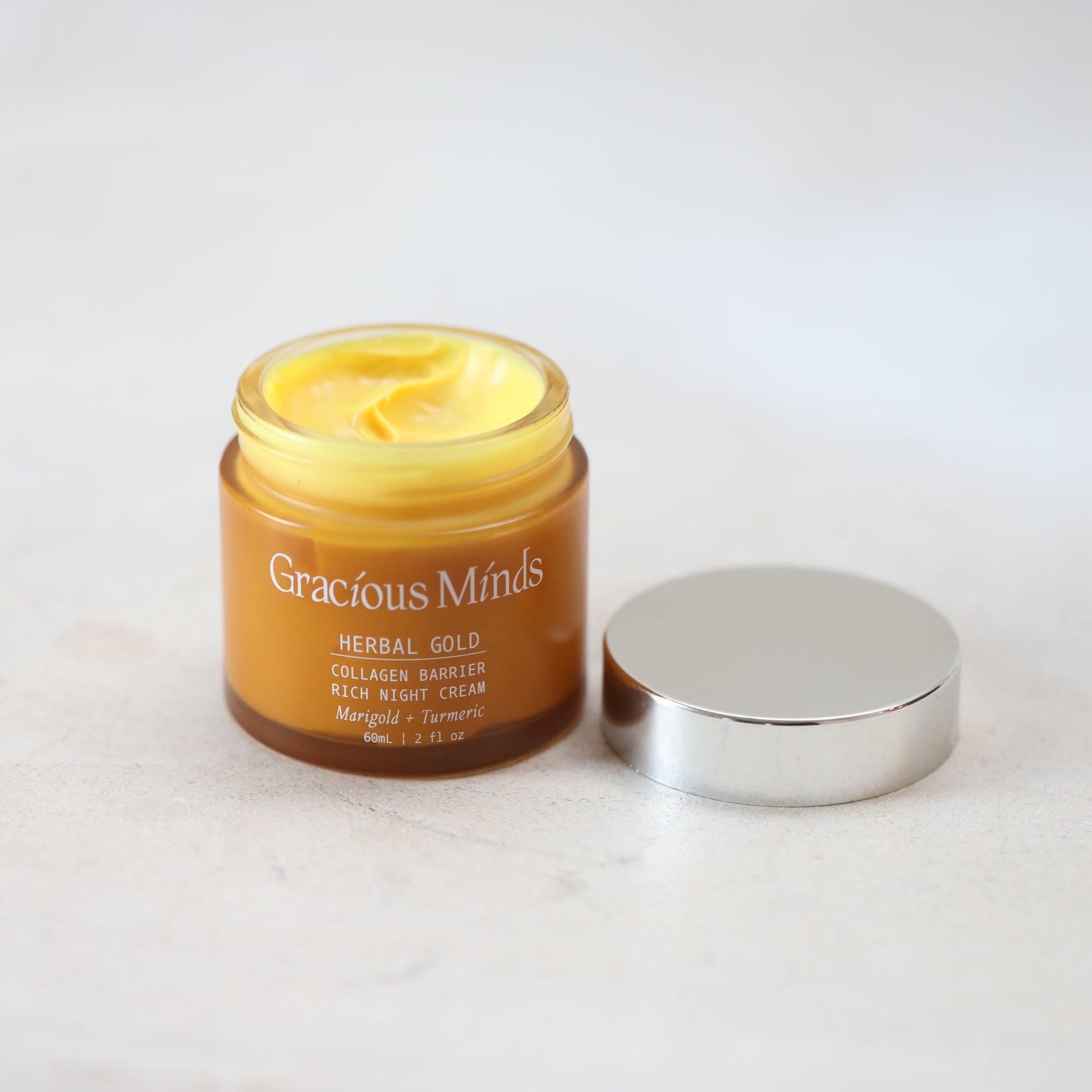 glass jar of Gracious Minds Herbal Gold cream on a white background