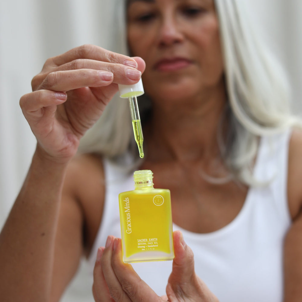 Gracious Minds Sacred Earth Sandalwood Revival Face Oil with turmeric root and ginseng, showcasing a lightweight formula designed for sensitive skin, enhancing hydration and promoting a balanced complexion.
