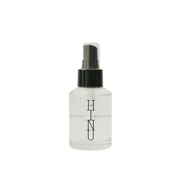 Glass bottle of HINU Hydrating Mist with a minimalist label — a lightweight floral mist designed to hydrate, balance the scalp, and soften hair and skin.
