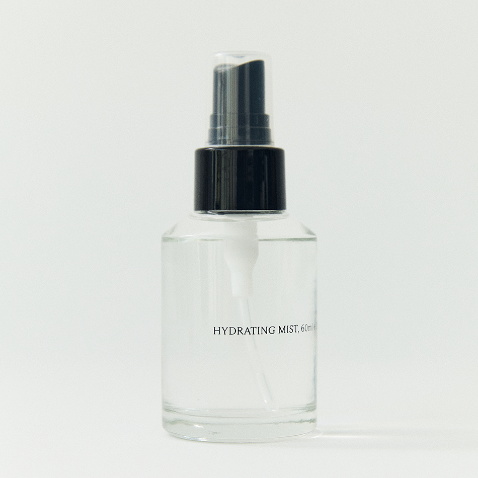 Glass bottle of HINU Hydrating Mist with a minimalist label — a lightweight floral mist designed to hydrate, balance the scalp, and soften hair and skin.