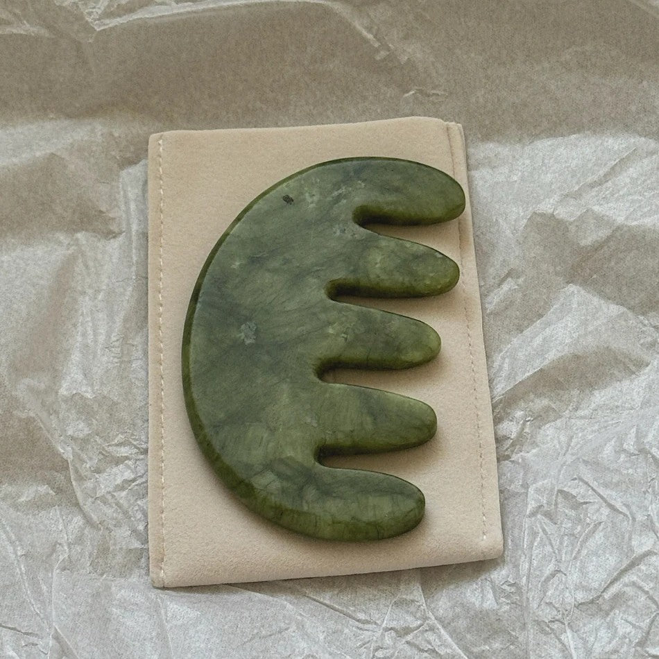 A hand-carved jade scalp stimulator made from natural Xiuyan jade, shown on a white background—designed to massage acupressure points on the scalp and enhance overall hair wellness.