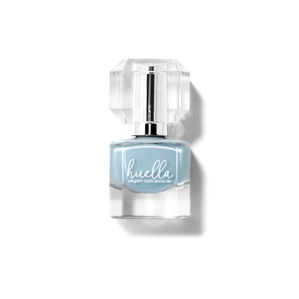Huella Cold as Ice nail lacquer in a frosted blue shade with gray undertones, featuring a 15-free, vegan, and chip-resistant formula.