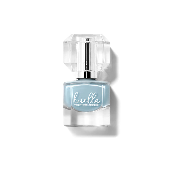Huella Cold as Ice nail lacquer in a frosted blue shade with gray undertones, featuring a 15-free, vegan, and chip-resistant formula.