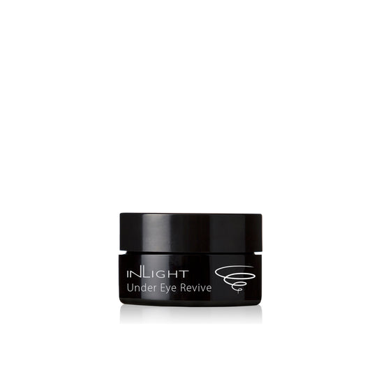 A jar of INLIGHT BEAUTY - Under Eye Revive, a moisturizing eye balm enriched with organic botanicals, ideal for reducing puffiness and brightening dark circles.