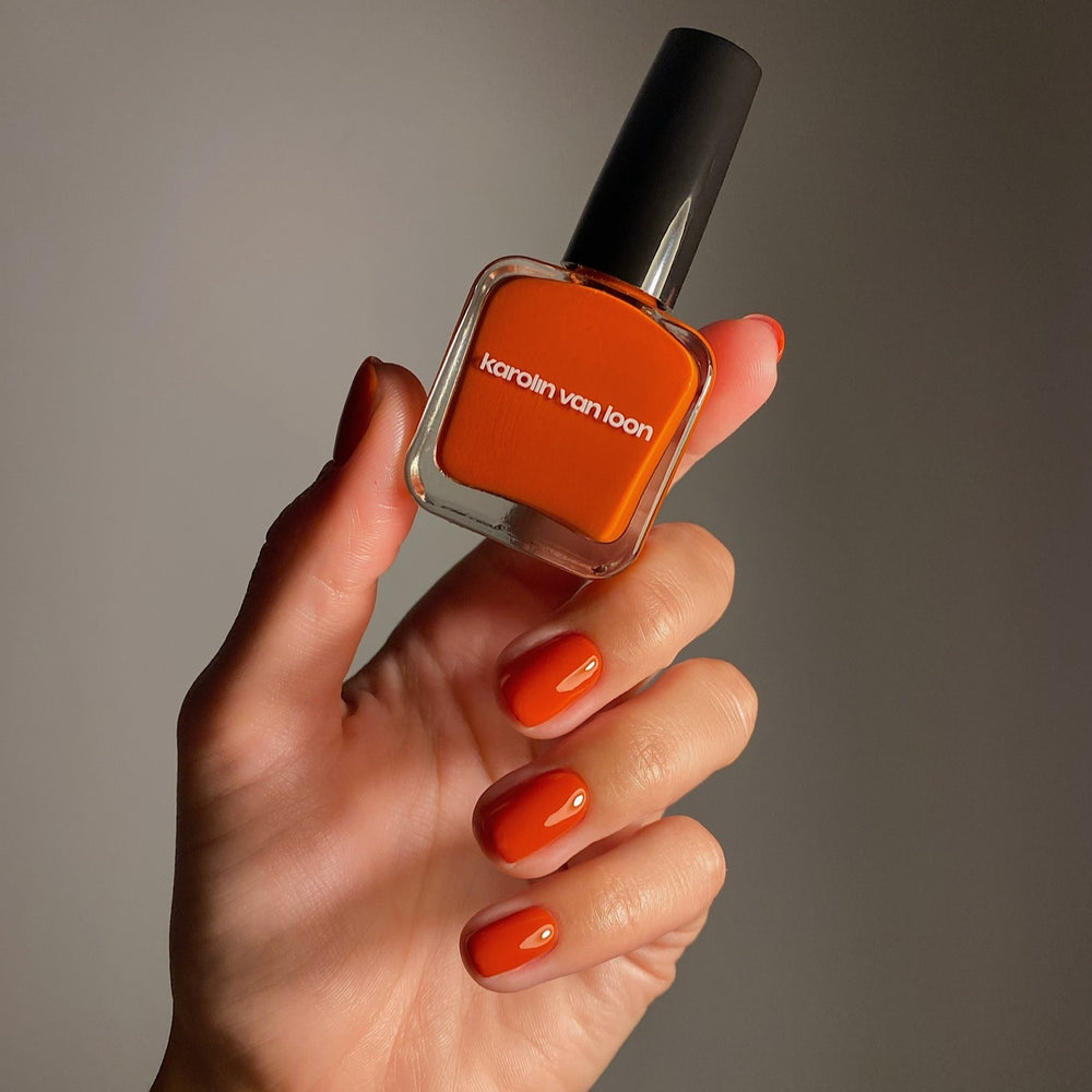 A bottle of Karolin Van Loon nail polish in shade 49 Sienne Cuir, featuring a warm terracotta color that evokes dreams of Moroccan deserts and Tuscan terraces, suitable for both summer and autumn palettes.