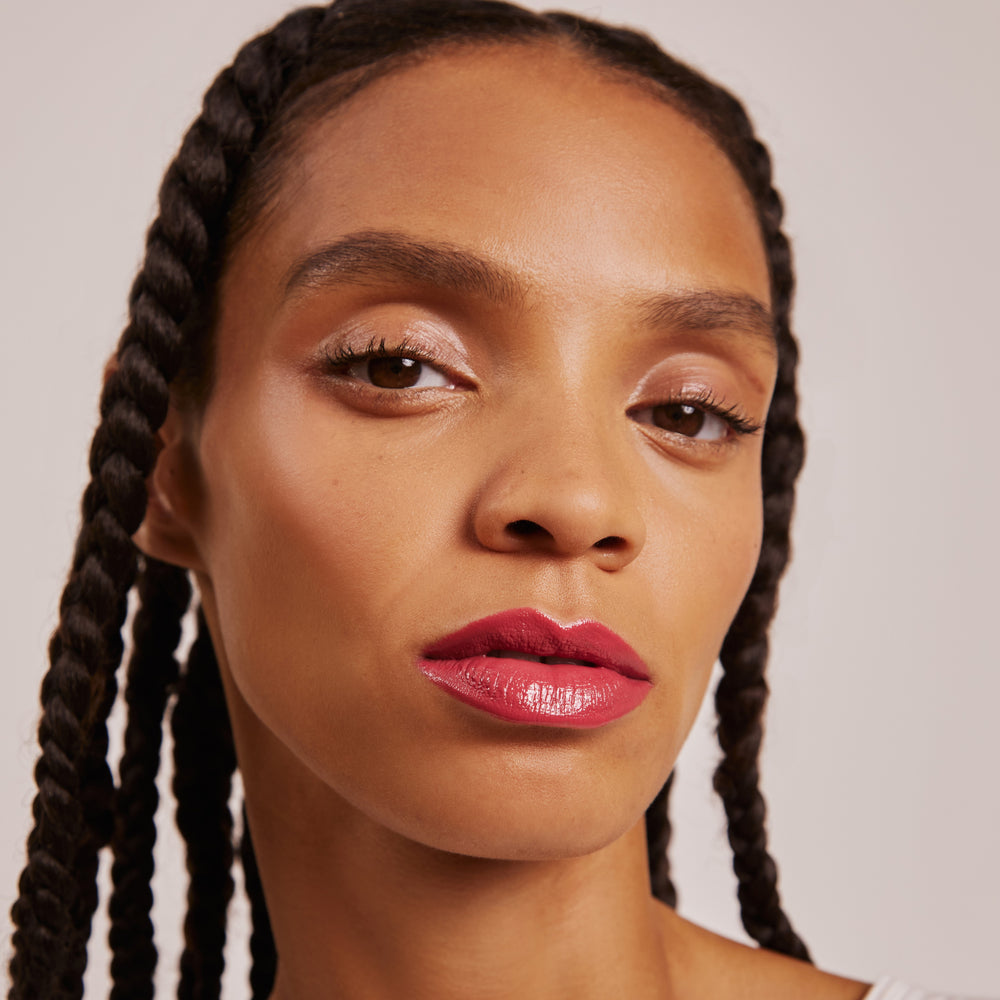 A tube of Karolin Van Loon lip gloss in In Love, showcasing a dusky rose hue that offers a pigmented and hydrating finish. This gloss provides radiant color and a soft, pillowy texture, enhancing lips with a beautiful shine while keeping them moisturized and full.