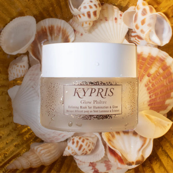 KYPRIS Glow Philtre jar surrounded by seashells on a textured surface