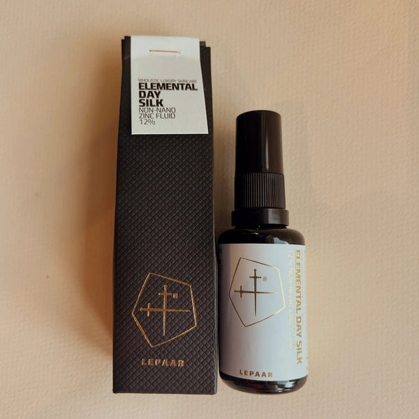Lepaar Elemental Silk hair product packaging on a beige background. LEPAAR Elemental Day Silk / 12% Non-Nano Zinc Outdoor Fluid