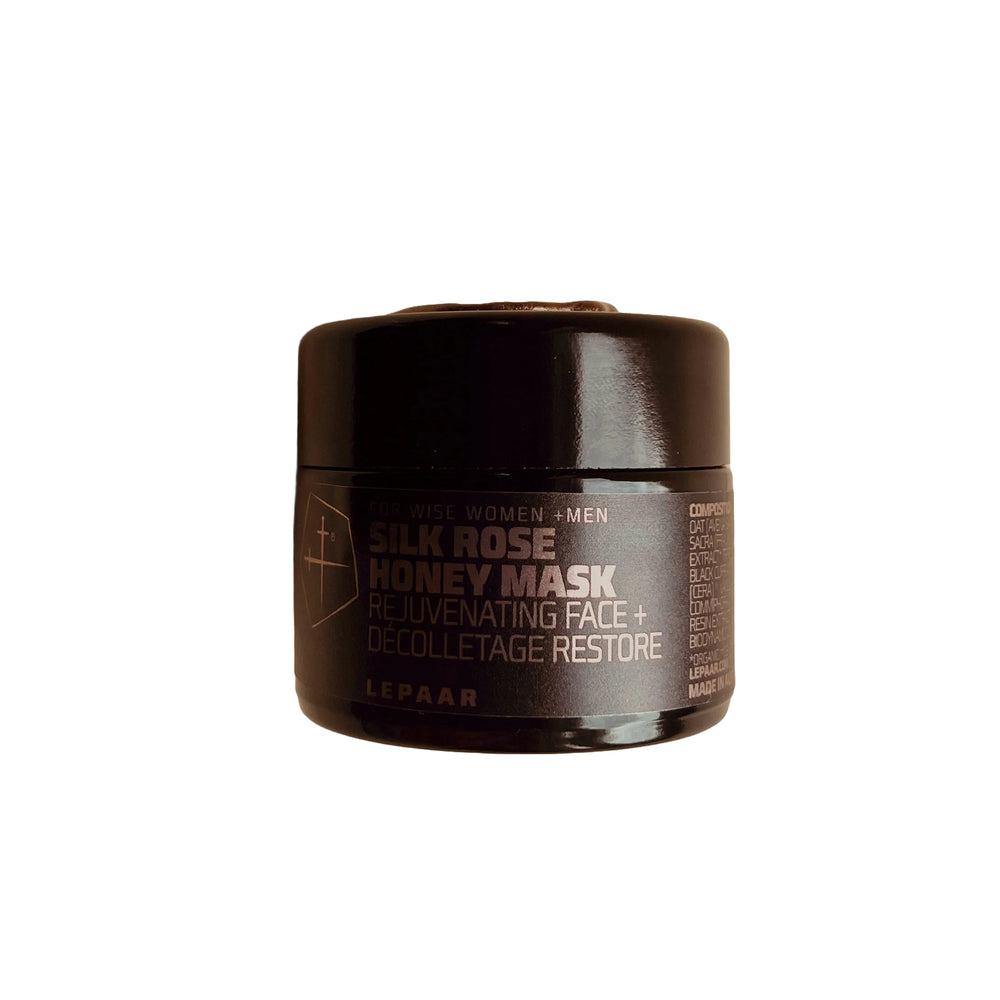 Black glass jar with a sleek minimalist design containing LEPAAR Silk Rose Honey Mask. The jar features a subtle gold emblem on the lid, reflecting a luxurious and elegant skincare product.