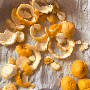 Dried yuzu peels and whole yuzus on a textured surface. LEPAAR Yuzu Vitamin C Serum Complexion Saving Antioxidant Concentrate