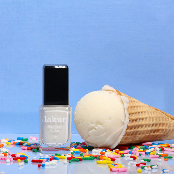 LONDONTOWN Double Scoop nail polish bottle with an ice cream cone and colorful candies on a blue background
