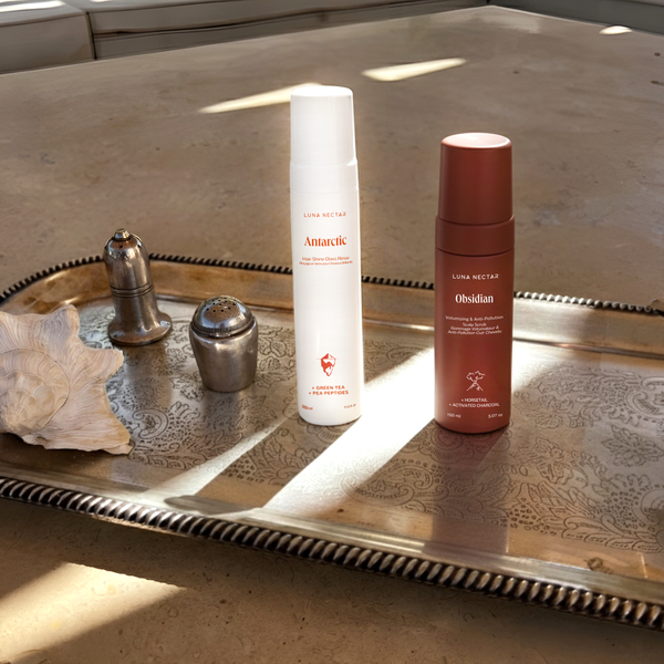 Two skincare products on a decorative metal tray with natural light.