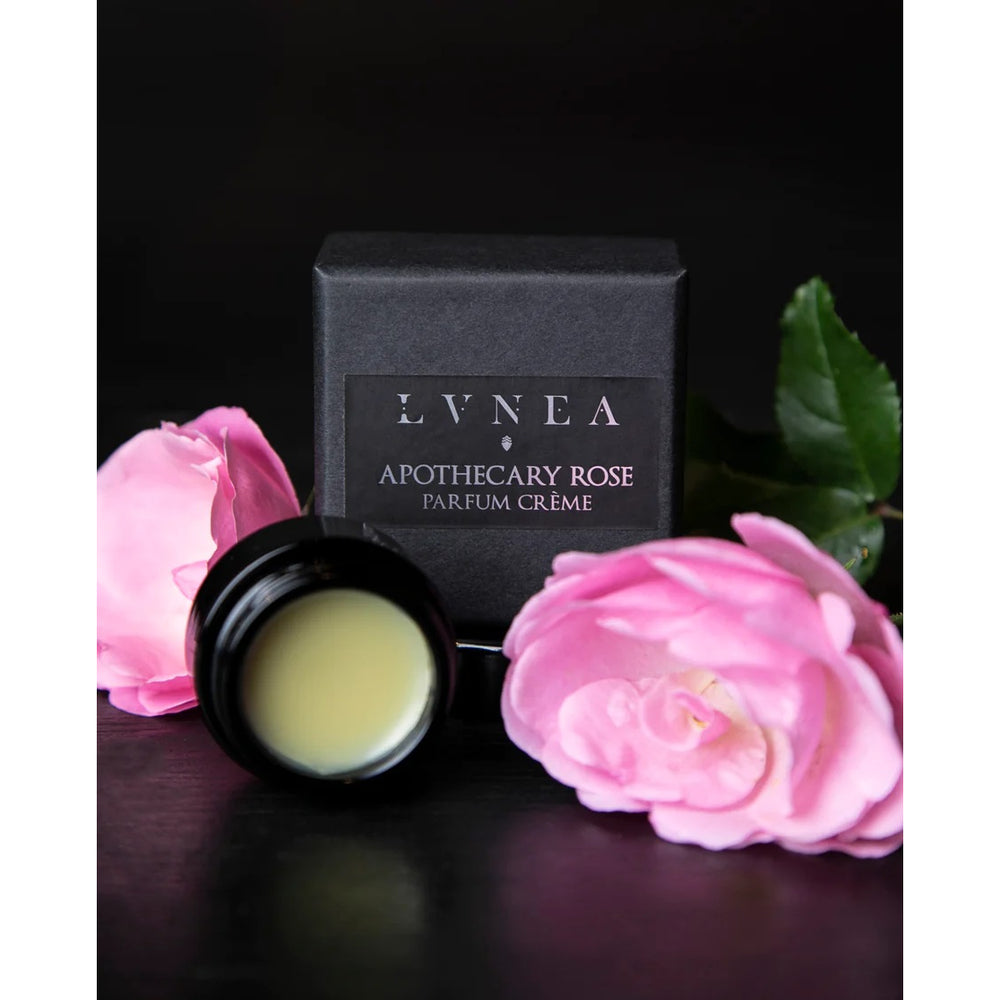LVNEA Apothecary Rose Parfum Crème in an amethyst glass pot, showcasing a creamy blend of rose gallica, apricot, myrrh, and tarragon, nestled in a gift box.