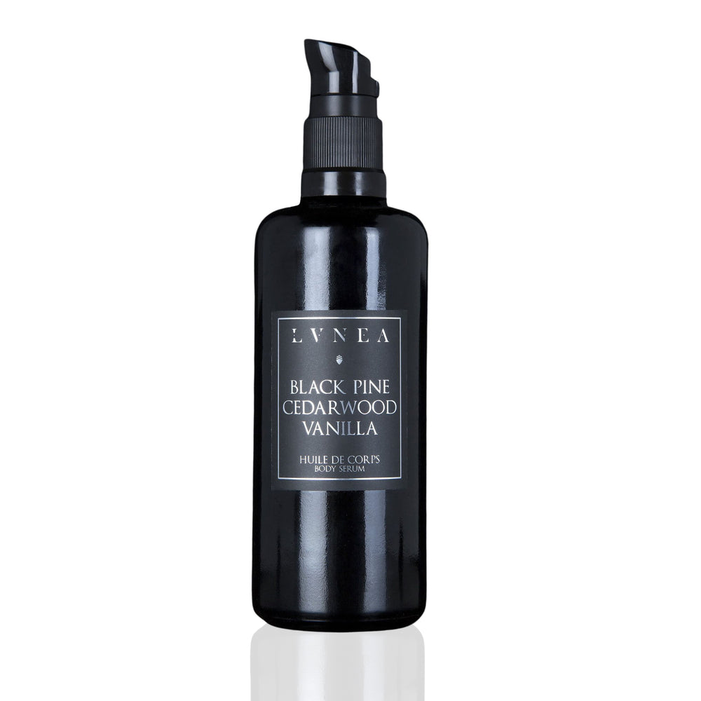 LVNEA Botanical Body Serum in an amethyst glass bottle with pump dispenser, showcasing the luxurious blend of black pine, cedarwood, and vanilla.