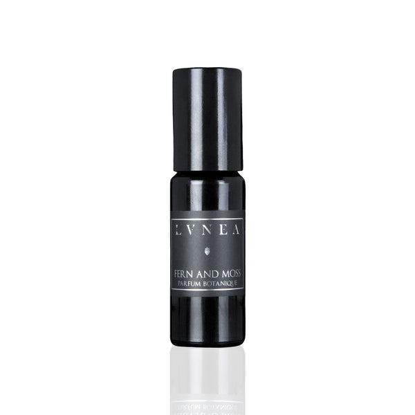 LVNEA Fern And Moss Parfum Botanique in an amethyst glass bottle with a roller ball, featuring notes of fresh herbs, lavender, tonka bean, and green moss. A soft, aromatic fragrance with green and coumarin aspects.