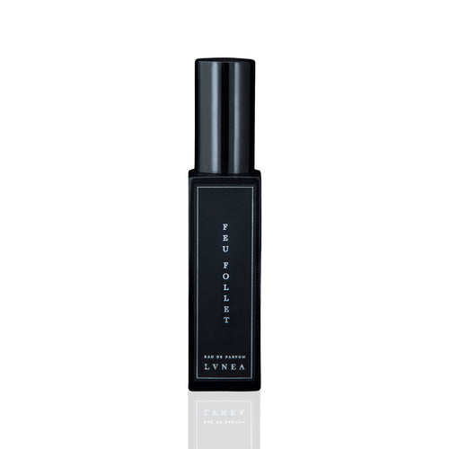 LVNEA Feu Follet Eau De Parfum - a black glass bottle containing a smoky, resinous fragrance with notes of pine tar, burnt wood, leather, and tree resin. Presented with an atomizer spray top. 30ml